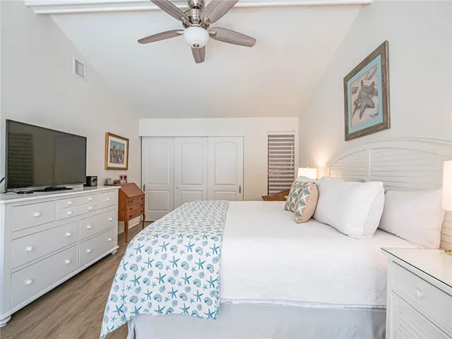 a bedroom with a large bed and a flat tv screen on dresser