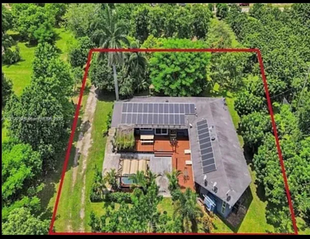 an aerial view of a house with swimming pool and garden