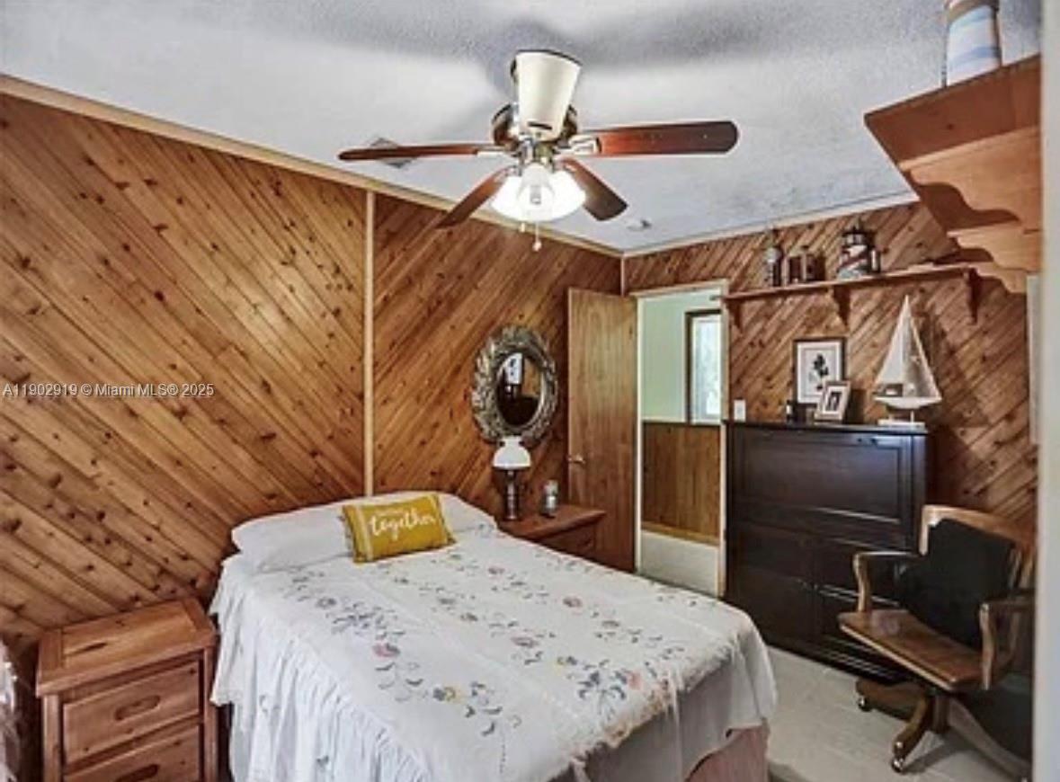 37225 Southwest 214th Avenue Homestead, FL 33034 - Photo 15 of 75 a bedroom with a bed and a chandelier