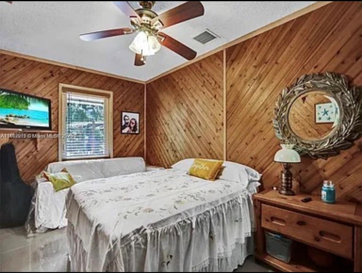 37225 Southwest 214th Avenue Homestead, FL 33034 - Photo 18 of 75 a bedroom with a bed and a chandelier