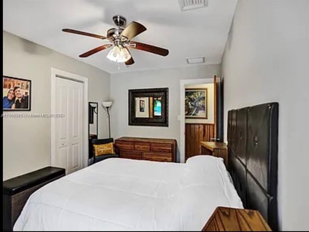 37225 Southwest 214th Avenue Homestead, FL 33034 - Photo 31 of 75 a bedroom with a bed and a chandelier