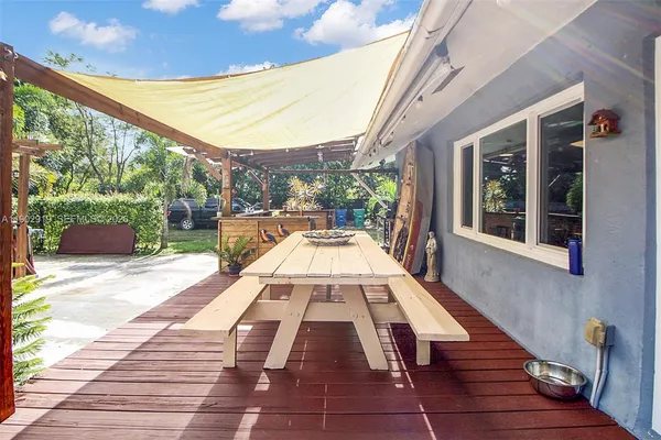 a living room with furniture a flat screen tv and a floor to ceiling window
