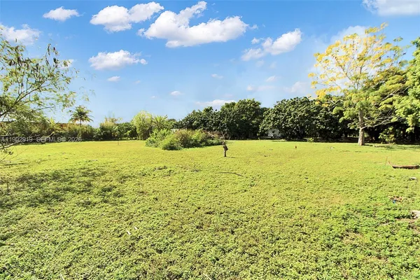 an aerial view of a house with a yard and covered with swimming pool