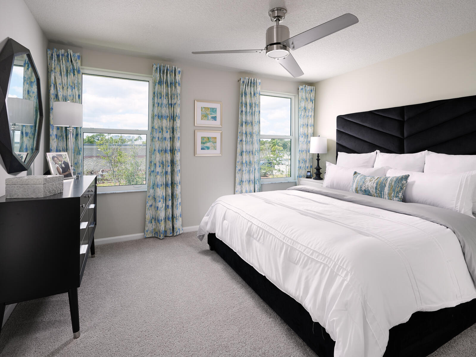 5700 Southeast Edgewater Circle Stuart, FL 34997 - Photo 2 of 9 a bedroom with a bed a mirror and a large window