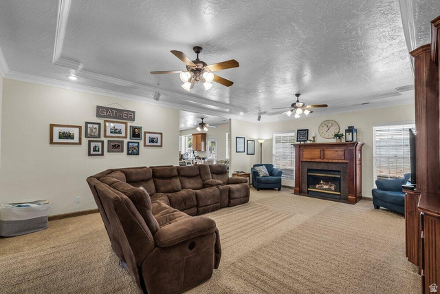 841 1010 S Street St. George, UT 84790 - Photo 5 of 33 Carpeted living room with a textured ceiling, crown molding, a fireplace with flush hearth, and healthy amount of natural light