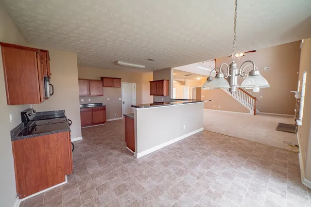 a open kitchen with cabinets and a stove