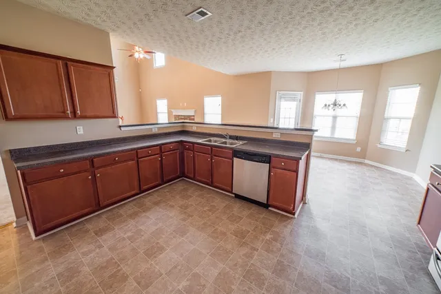 a large kitchen with wooden cabinets and a granite counter tops