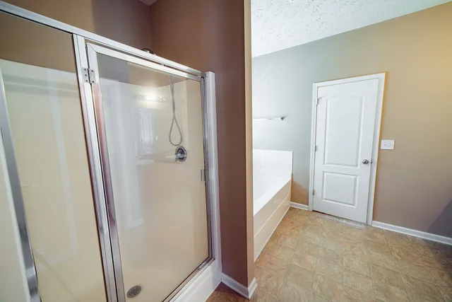 an empty room with windows and ceiling fan