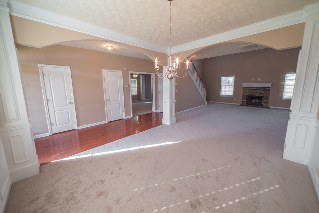 45 Apache Trail Fort Mitchell, AL 36856 - Photo 5 of 43 en empty room with chandelier fan and fireplace