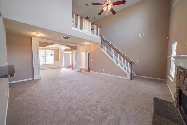 a view of an empty room with a fireplace and a window