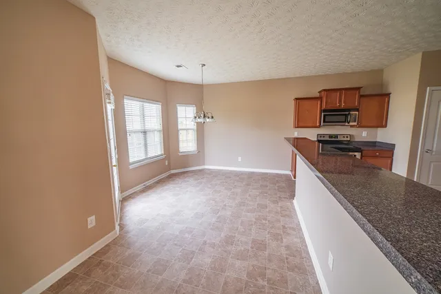 a kitchen with granite countertop a stove and a refrigerator