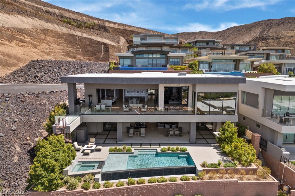 657 Ridgestone Rim Court Henderson, NV 89012 - Photo 95 of 97 Multi-level modern architecture commands attention against a dramatic desert hillside backdrop.