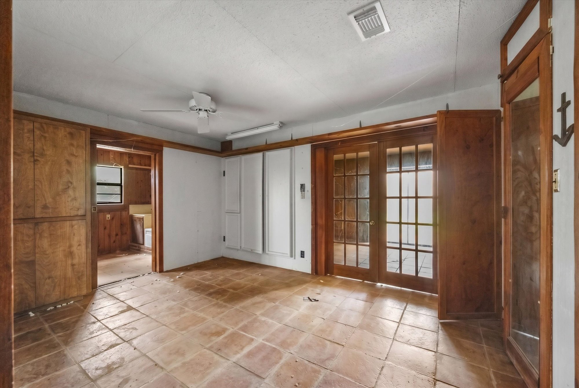 14201 Lund - Carlson Road Coupland, TX 78615 - Photo 30 of 40 Functional room features warm wood paneling, tile flooring, and glass-paned double doors.