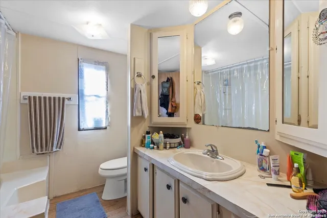 a bathroom with a sink vanity mirror and toilet