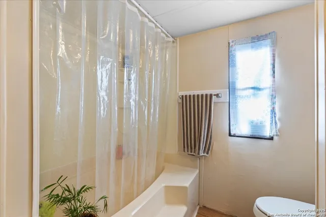 a bathroom with a shower curtain and a toilet