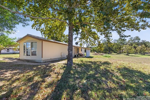 a view of a house with backyard and tree