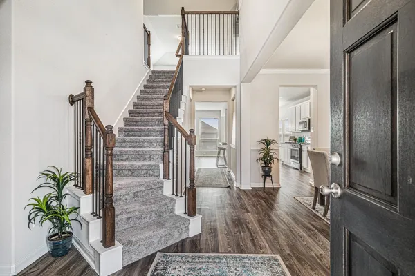 a view of a hallway with wooden floor and staircase