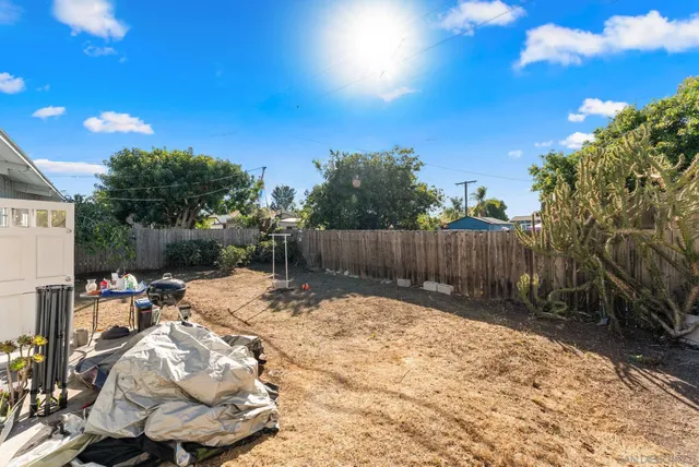 a view of a patio with table and chairs with plants and wooden fence