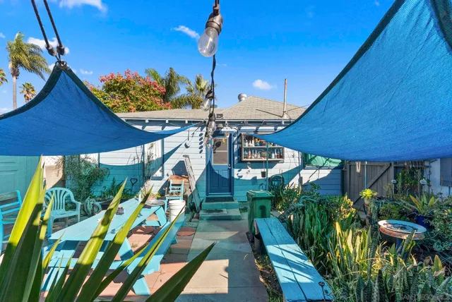 a patio with a table and chairs under an umbrella
