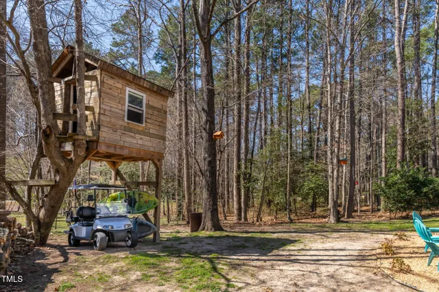 a front view of a house with a garden and trees