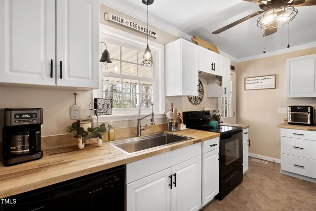 a kitchen with a sink dishwasher and white cabinets