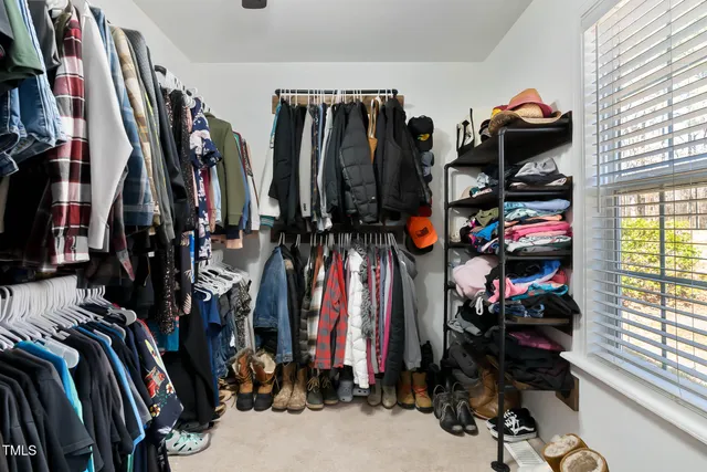 a view of walk in closet with clothes and shoes