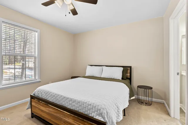a large bed in a bedroom next to a window
