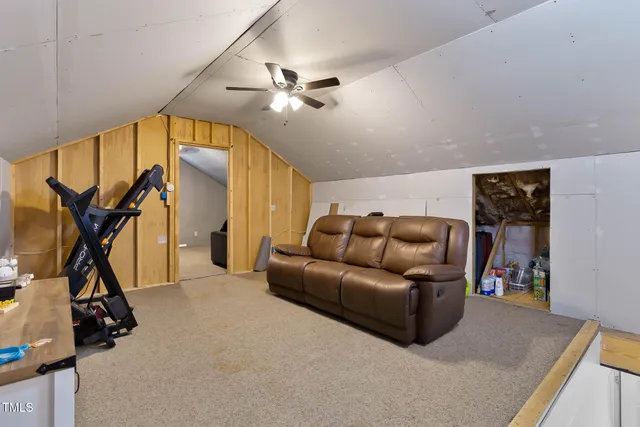 a living room with furniture a flat screen tv and a window