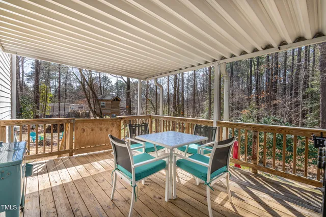 a balcony with wooden floor and outdoor seating