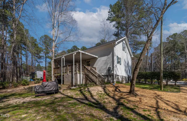 a view of a house with large trees and a small yard