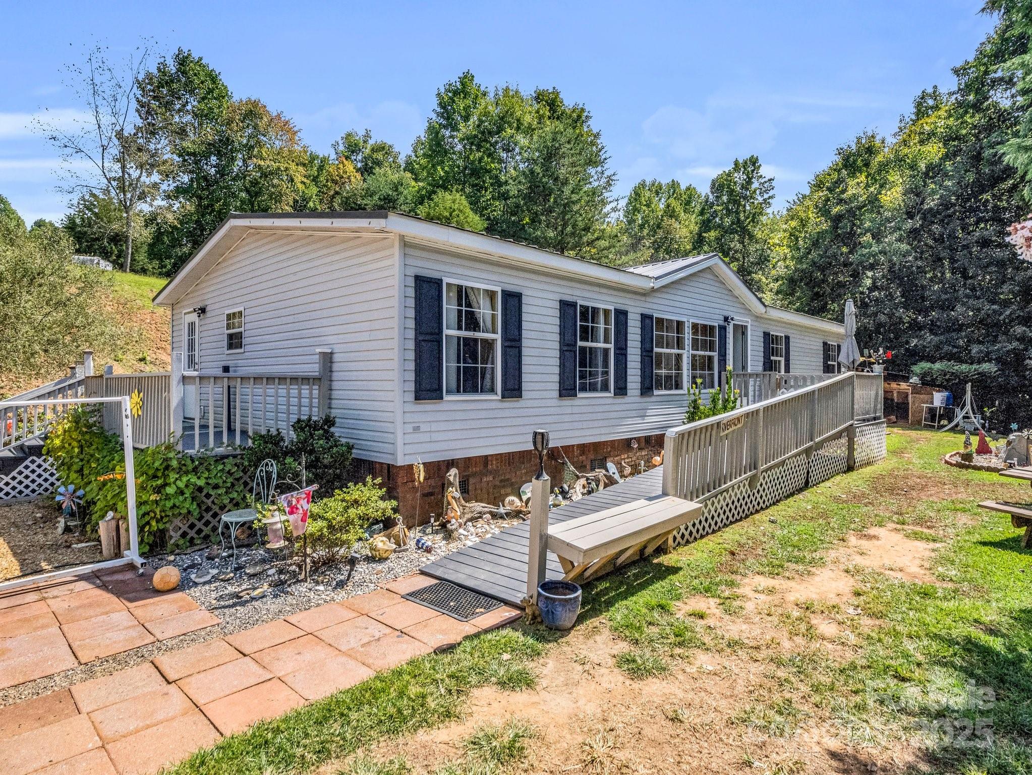 282 Reagan Lane Bostic, NC 28018 - Photo 2 of 34 a view of a house with wooden deck and furniture