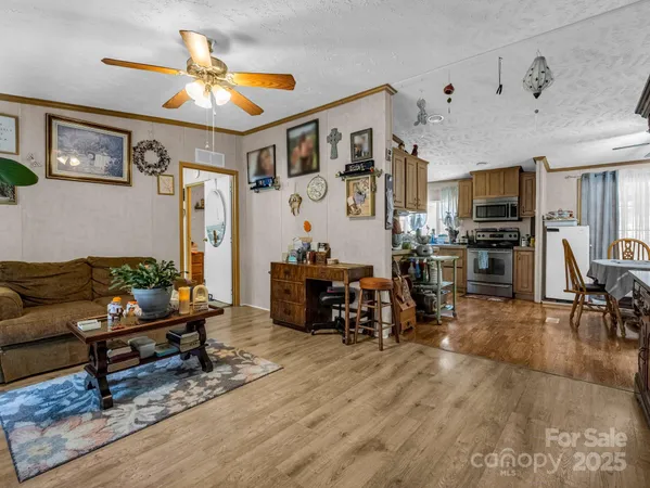 a living room with furniture kitchen view and a wooden floor