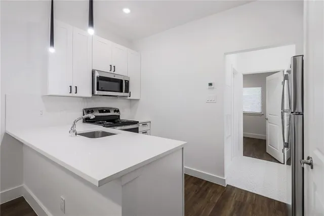 a kitchen with a refrigerator a stove a microwave and cabinets