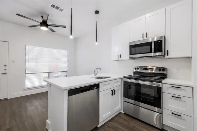 a kitchen with stainless steel appliances a stove sink and microwave