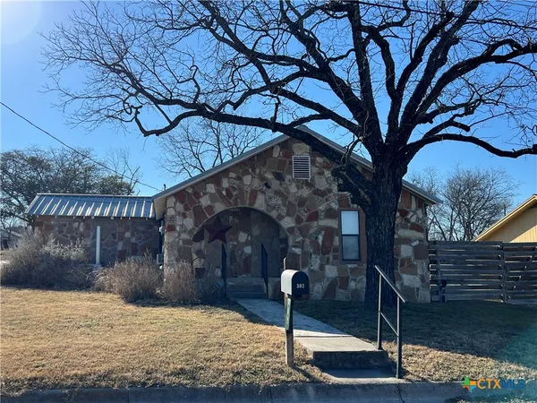 a house view with a tree in front of it