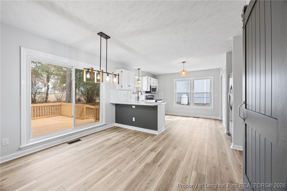 610 Duncan Road Spring Lake, NC 28390 - Photo 10 of 34 a large kitchen with granite countertop a large window and a wooden floor
