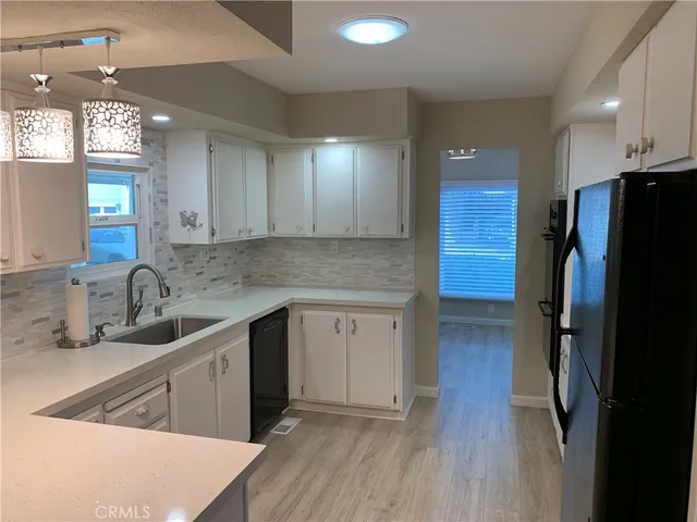 a kitchen with stainless steel appliances granite countertop a refrigerator a sink and a stove