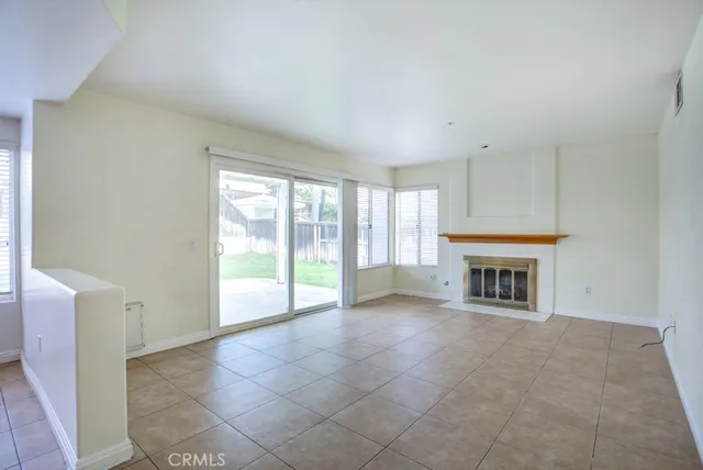 a view of an empty room with a fireplace and a window