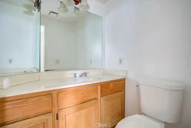 a bathroom with a granite countertop sink mirror vanity and toilet