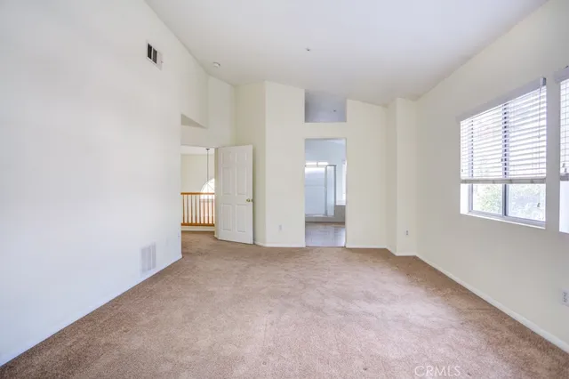 a view of empty room with windows and bathroom