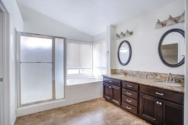 a bathroom with a double vanity sink a mirror and a bathtub
