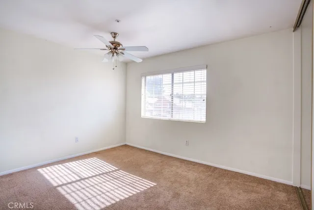 an empty room with windows and fan