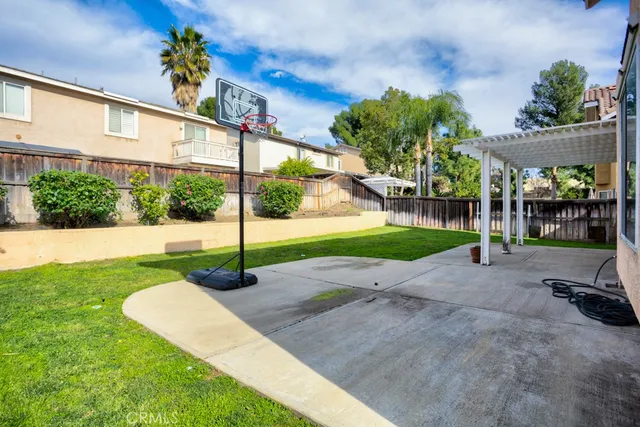 a view of a white house with a small yard and floor to ceiling window