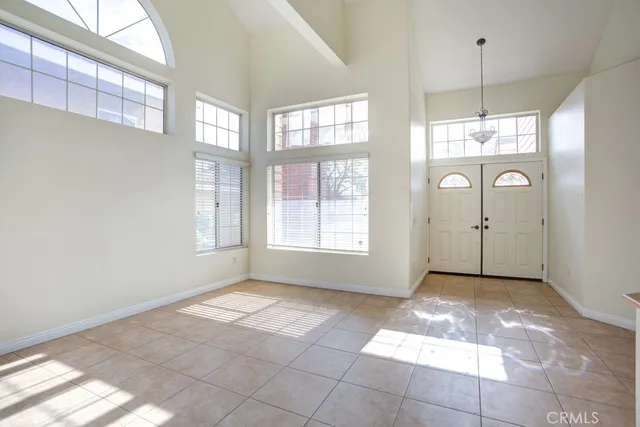 a view of a big room with windows and chandelier fan