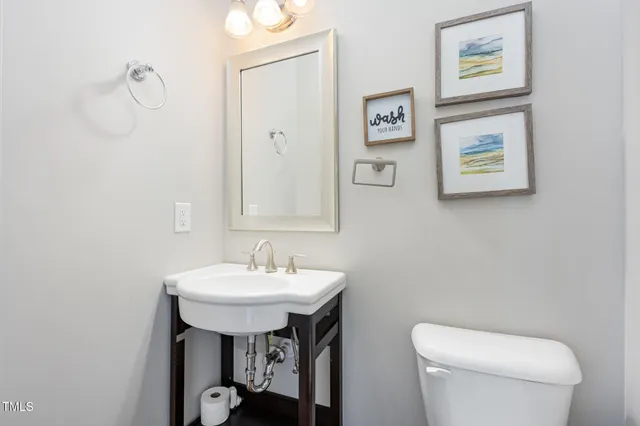 a bathroom with a toilet a sink and mirror