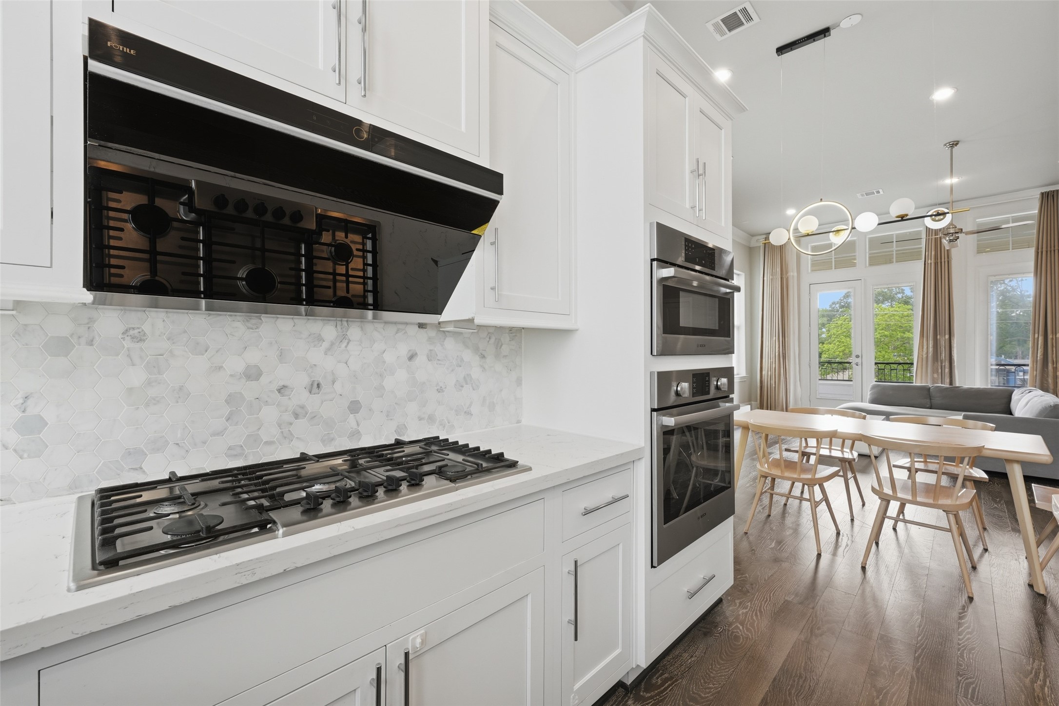 8612 Emnora Lane Houston, TX 77080 - Photo 12 of 45 a kitchen with a stove a microwave and wooden floor