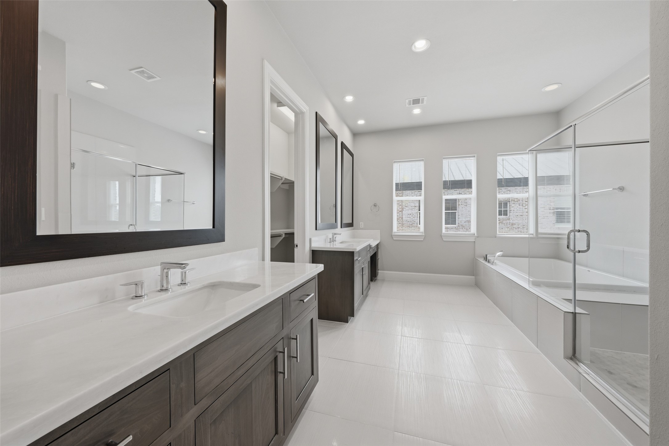 8612 Emnora Lane Houston, TX 77080 - Photo 27 of 45 a bathroom with a double vanity sink a mirror and a bathtub