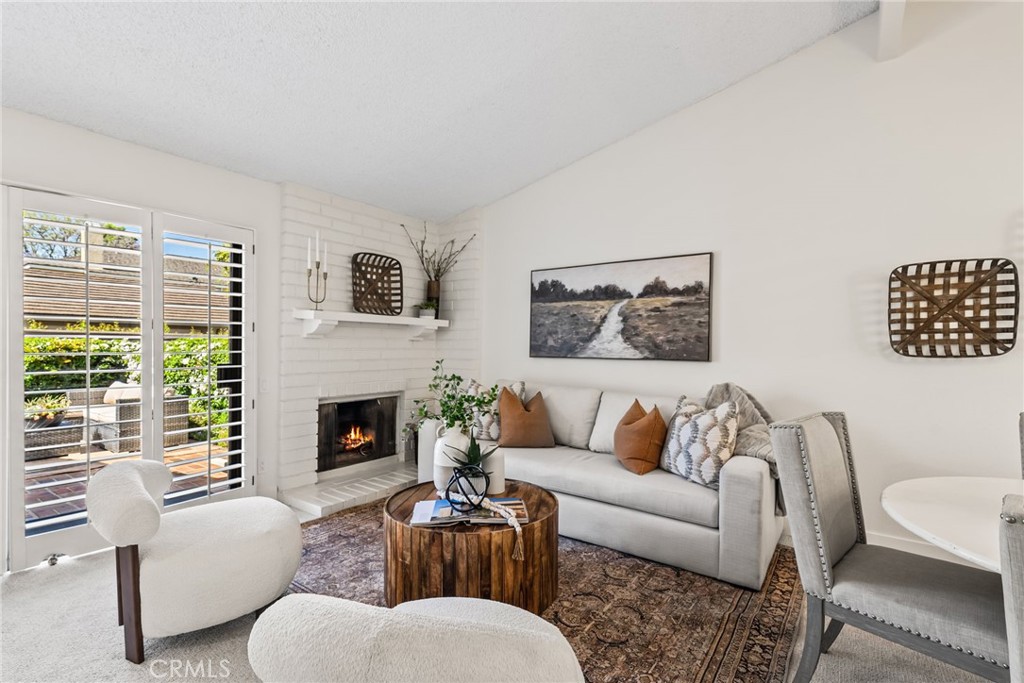 a living room with furniture fireplace and a large window