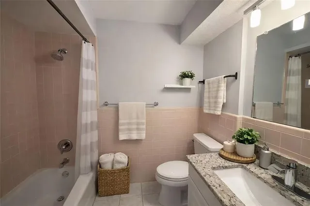 a bathroom with a granite countertop toilet a sink and a bathtub