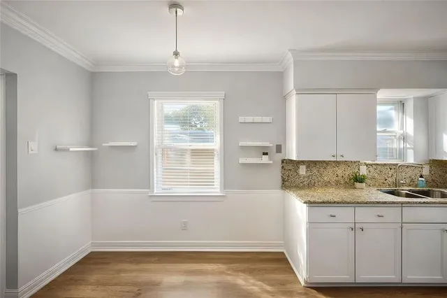 a kitchen with a window cabinets and a wooden floor